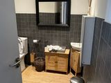 une salle de bains équipée de toilettes, d'un lavabo et d'un miroir