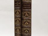 two old books sitting on top of each other on a white surface