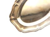 une assiette en argent posée sur une table, sur fond blanc