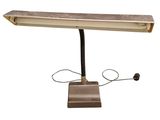 une image représentant une lampe de bureau sur fond blanc, avec un cordon d'alimentation