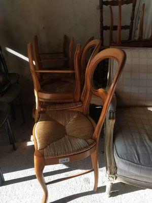 plusieurs chaises et un canapé dans une pièce avec une fenêtre à l'arrière-plan