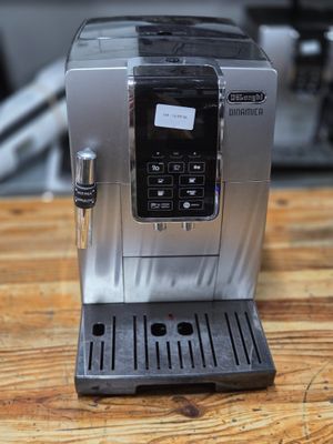 an espressor machine sitting on a wooden table in a kitchen