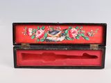 a red box with a bird and flowers painted on it