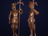 a pair of bronze statues of men with spears and shields