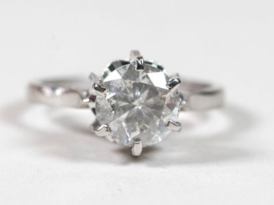 gros plan d'une bague en diamant sur une surface blanche