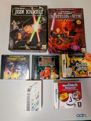 de nombreux jeux vidéo posés sur la table et une Nintendo Wii