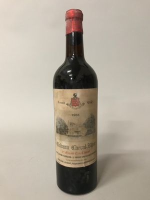 une vieille bouteille de vin posée sur une table blanche