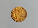 a close up of a gold coin on a white surface