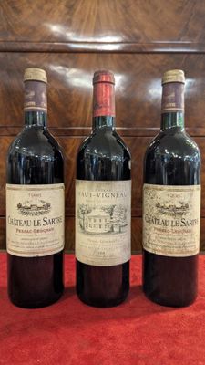 three bottles of wine are lined up on a red cloth
