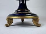 a blue and gold vase sitting on top of a table