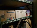 a shelf full of beer bottles and boxes with a sign on it