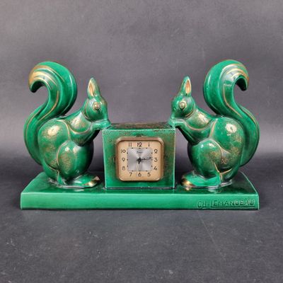 une horloge verte sur laquelle sont assis deux écureuils