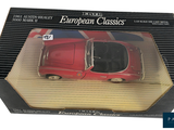a red toy car in a box on a white background