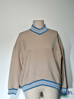 un mannequin vêtu d'un pull et d'un pantalon, posé sur un socle de mannequin