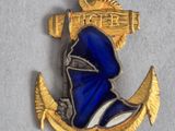 une image représentant une épinglette bleue et dorée sur laquelle figure un bonnet de marin