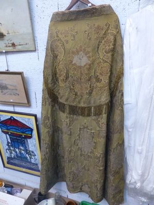 une robe sur un cintre dans une pièce où sont accrochés des tableaux au mur