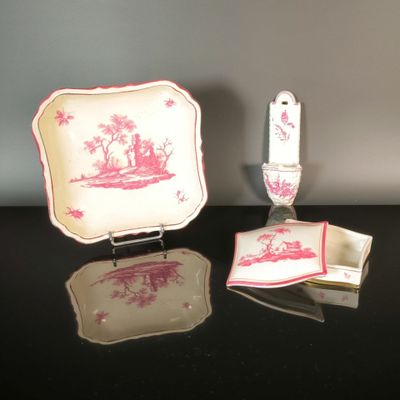 a pink and white plate with a red design on it