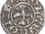 a close up of a silver coin with a cross on it