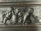 a metal plaque with a boy and a girl playing in the water