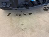 a car that is parked in a garage with dirt on the ground