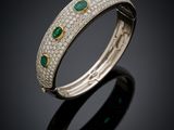 un bracelet rigide orné de diamants et d'émeraudes