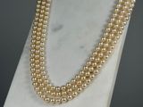 a close up of a pearl necklace on a mannequin stand