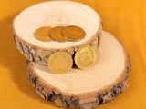 two coins sitting on top of a piece of wood