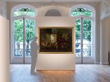 a statue that is standing in front of a painting