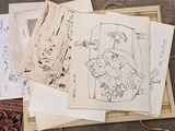 a pile of drawings sitting on top of a wooden table