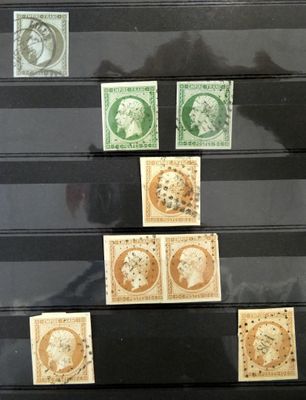 Plusieurs timbres différents sont exposés dans une vitrine posée sur une table.