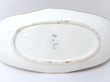 a white plate with a bird on it on a white surface