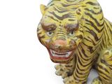 a statue of a tiger that is sitting on a white surface