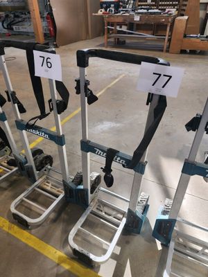 Plusieurs chariots à bagages portant des numéros sont alignés dans un entrepôt