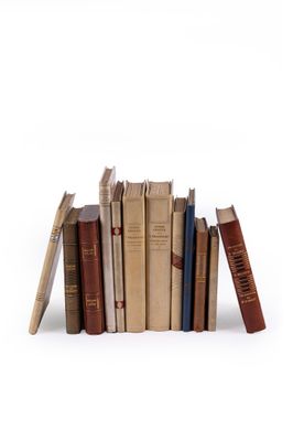 plusieurs vieux livres sont empilés sur une surface blanche
