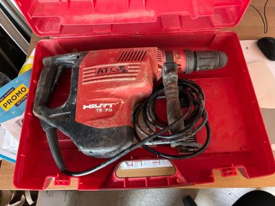 une boîte rouge contenant une perceuse, posée sur une table