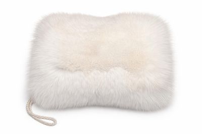 un gros plan d'un coussin en fourrure blanche sur fond blanc