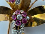 a close up of a flower brooch with pink and white stones