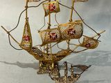 une maquette en or d'un voilier posée sur une table