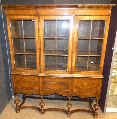 un vaisselier en bois avec des portes en verre dans une pièce