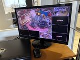 a monitor on a desk with a keyboard and mouse