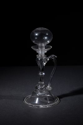 a clear glass candle holder on a black table