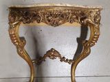 a gold table with a marble top on a white floor