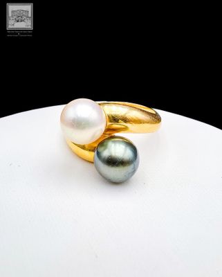 une photo en gros plan d'une bague ornée de deux perles