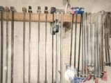 many golf clubs hanging on a rack in a room