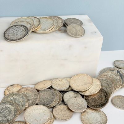 un tas de pièces posé sur un bloc de marbre