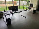 a desk with a computer and a monitor in a room