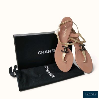 des sandales Chanel dans une boîte, avec un sac noir et une paire de sandales