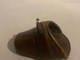 a brown shoe that is laying on a white surface