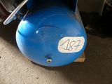 a blue air compressor sitting on top of a wooden pallet