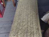 a wicker bench sitting on the porch of a house